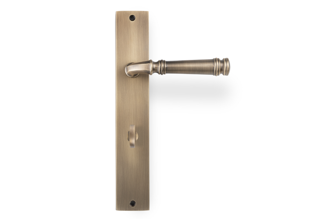 Product picture of the Apollo Design Tuscany Door Handle on Rectangle Plate Antique Brass Privacy Set on a white background.