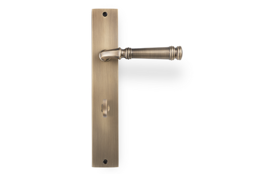 Product picture of the Apollo Design Tuscany Door Handle on Rectangle Plate Antique Brass Privacy Set on a white background.