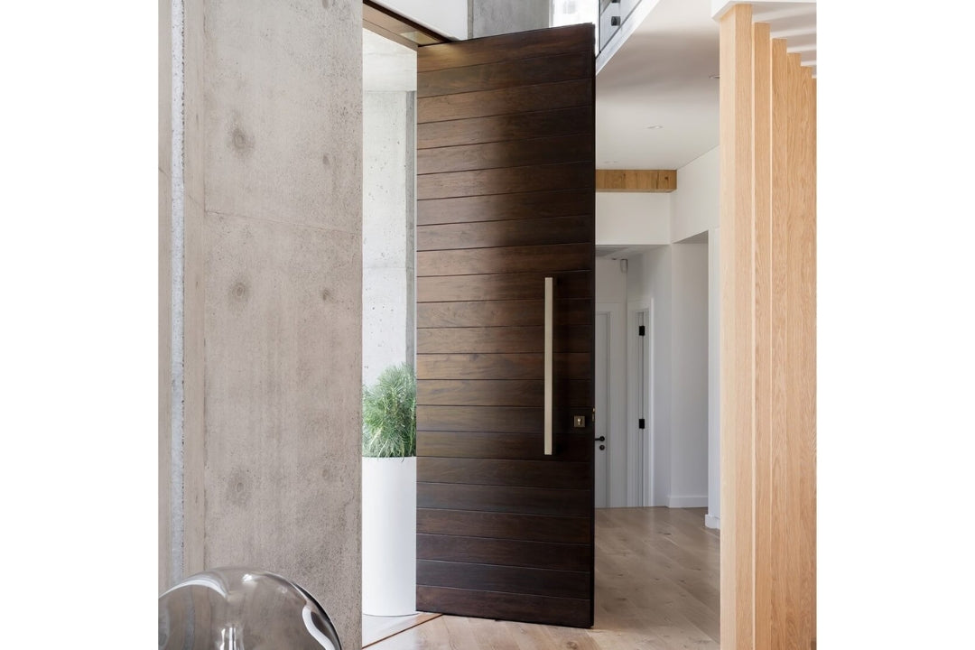 Interior view of the 7101 Polo Pull Handle installed on a dark brown wooden door with pine wooden feature on the interior.
