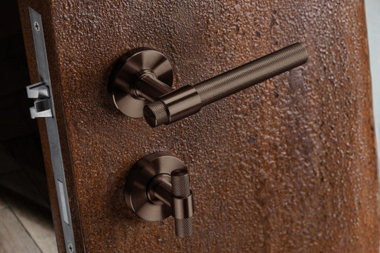 Bronze door handle and lock on a textured wooden door