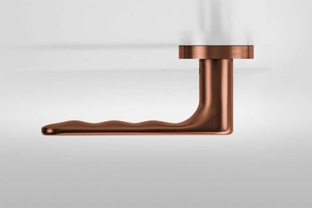 Insitu profile photo of the Yokohama Titanium Copper Door Handles on an off white background.