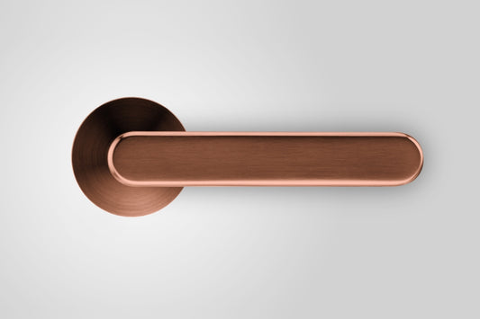 Insitu front on photo of the Yokohama Titanium Copper Door Handles on an off white background.