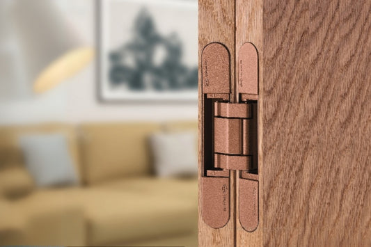 Insitu image of the IN.05.061.SC Coplan Hinge on a wooden door with a blurred out lounge room in the background.
