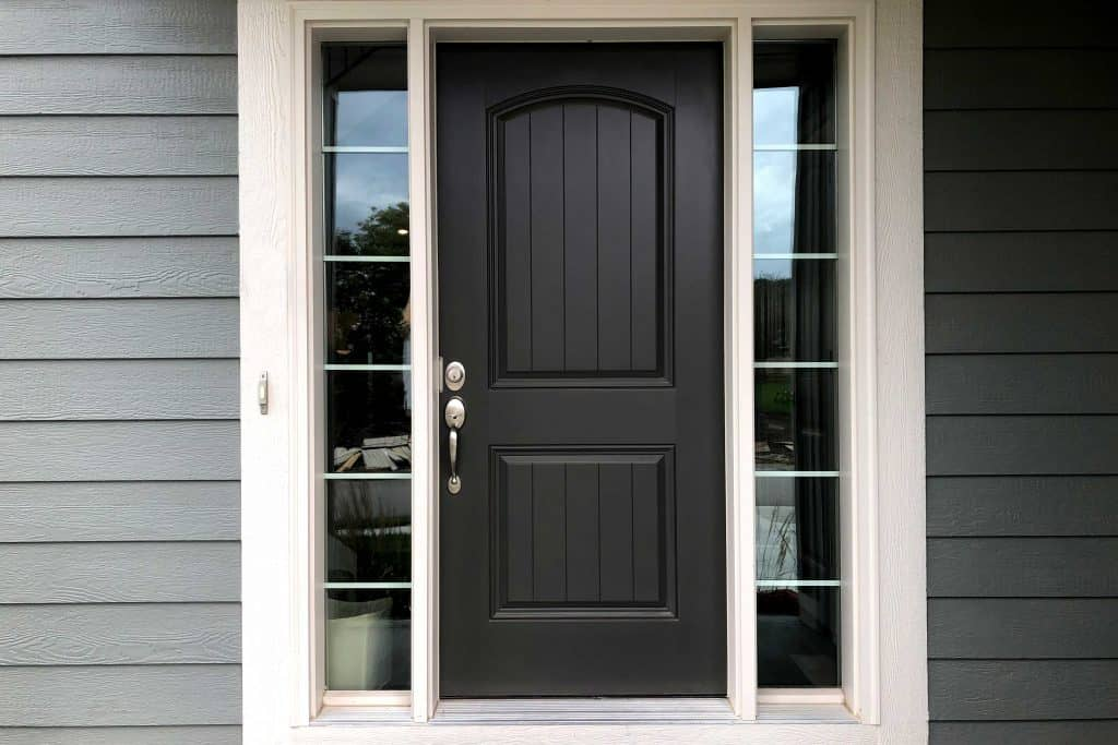 Black door with white trim and brushed nickel door hardware. There are two windows on each side of the door.