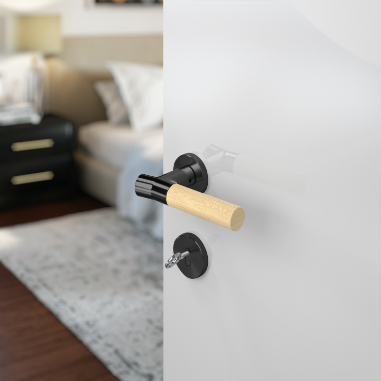 Wood Nature Matt Black with Bamboo door handles on a off white door with a blurred out bedroom in the background.