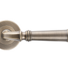 Product image of the Apollo Design Tuscany Door Lever Handle on Round Rose Pair Antique Brass on a white background.