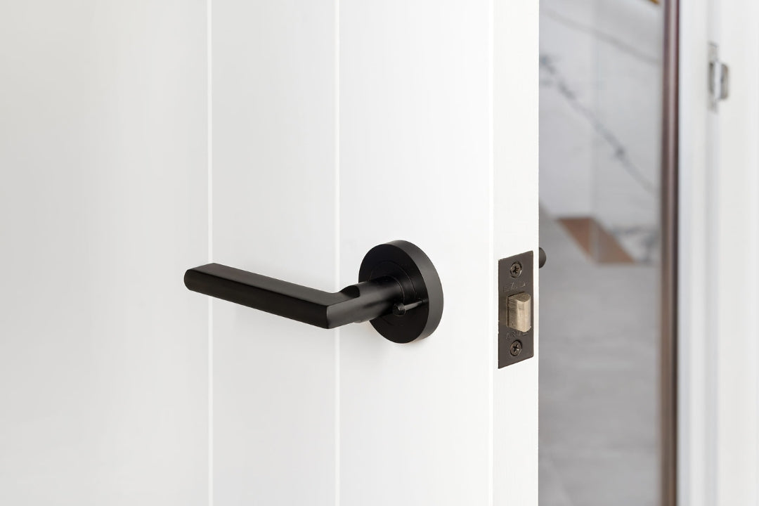 Insitu image of the Epic Matt Black Privacy Door Handle on a white door.