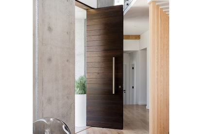 Interior view of the 7101 Urban Pull Handle installed on a dark brown wooden door with pine wooden feature on the interior.