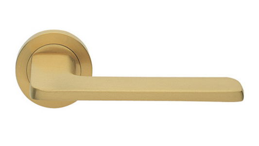 The Blade door handle in satin brass on a white background.