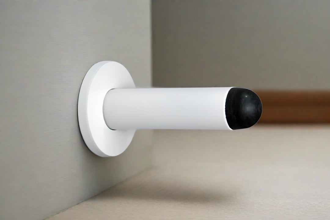 The White Pencil Wall Mounted Door Stop installed on door.