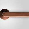 Insitu front on photo of the Yokohama Titanium Copper Door Handles on an off white background.