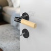JNF Wood Nature IN.00.381.BB.TB Bamboo Titanium Black lever handle on a white door with a blurred background.