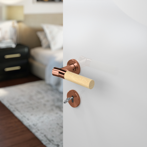 Insitu photo of the Wood Nature Titanium Copper Bamboo Door Handle on a white door with a bedroom blurred out in the background.