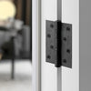 The JNF Ball Bearing Hinge 100x75mm Matt Black installed on an off white door.