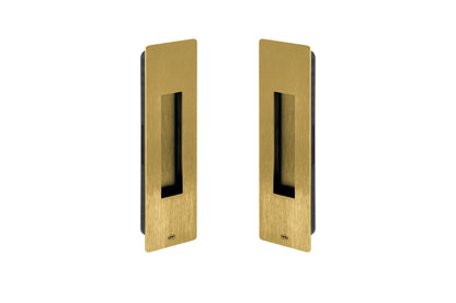 Two gold rectangular door handles on a white background