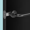 Insitu image of the IN.20.153.TB matt black tube latch on a black door with a generic matt black lever handle installed.