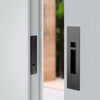 Image of the IN.20.925.TB Matt Black Sliding Door Privacy Kit installed on an off white door.