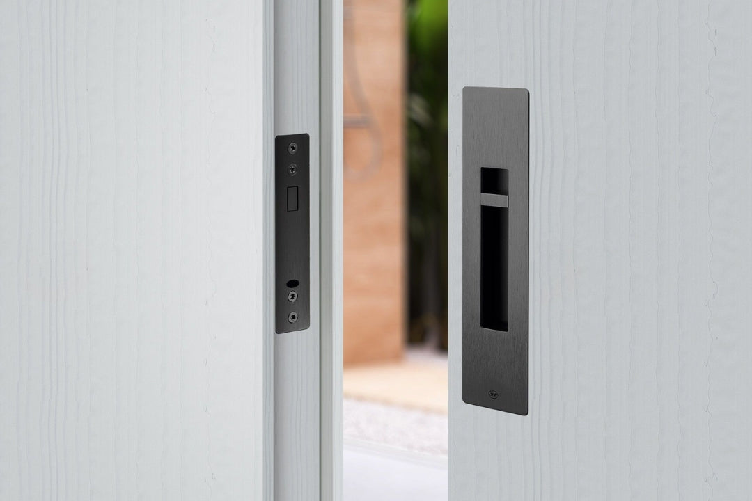 Close-up of a modern door handle and lock mechanism on a light gray door.