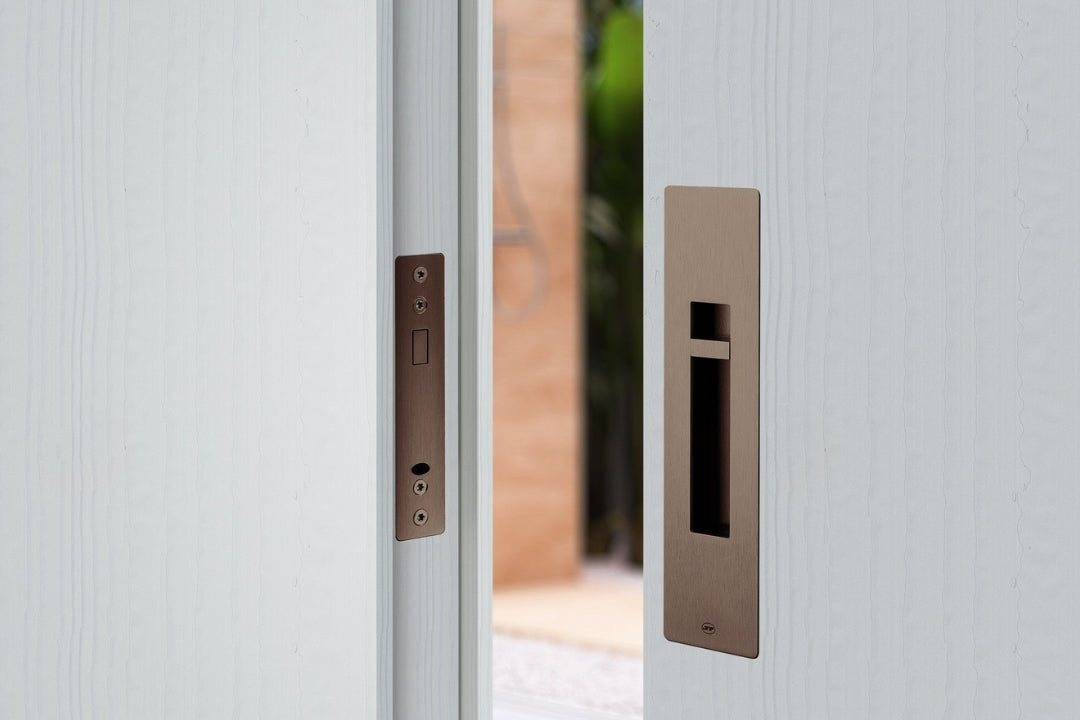 Close-up of a white door with chocolate PVD handle and lock mechanism.