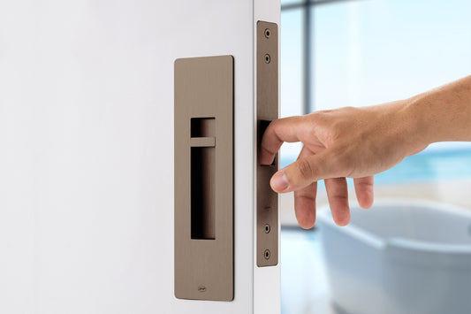 Hand opening a door with a modern chocolate handle