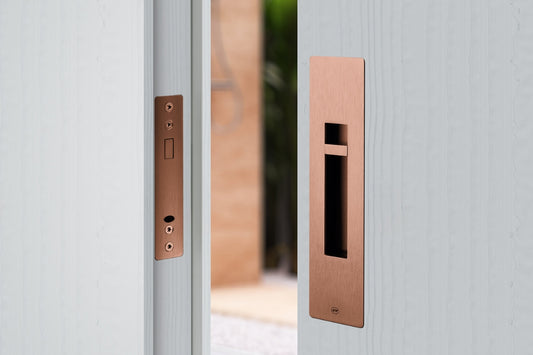 Copper door handle and lock on a wooden sliding door