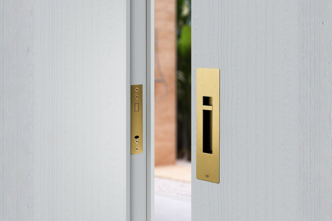 Close-up of a door with gold handle and lock on a light gray background