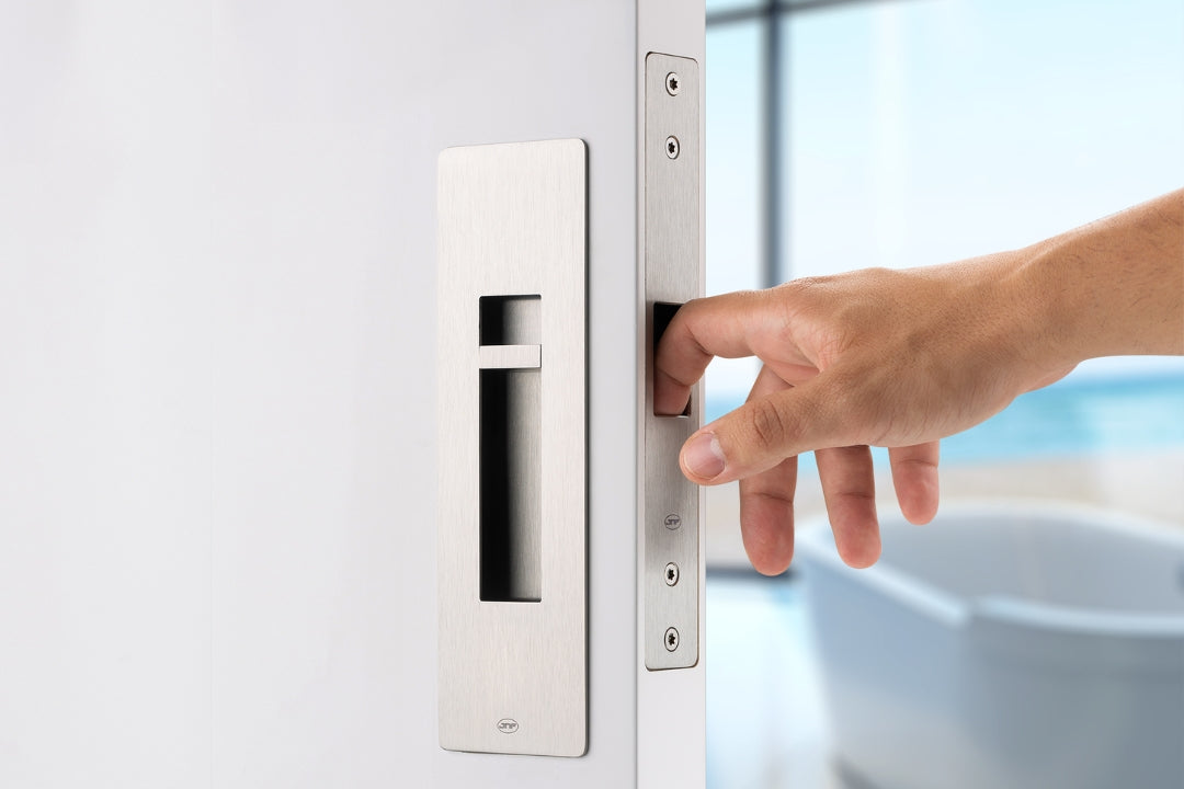Hand opening a door with a modern handle design.