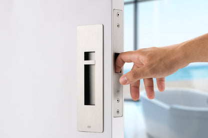 Hand opening a door with a modern handle design.