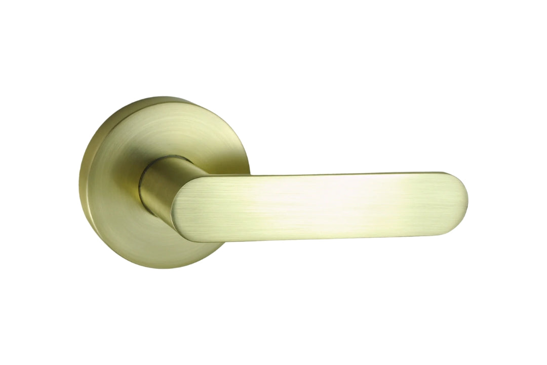 Image of the Satin Brass Nidus Spring Door Lever Round Passage Set on a white background.