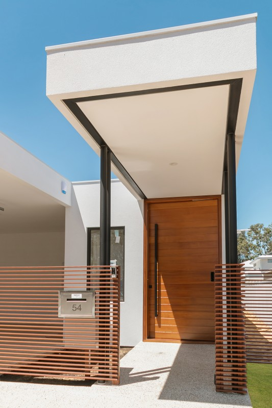 The 1800mm Ultra Matt Black pull handle installed on a vanished wooden door and white surrounds.