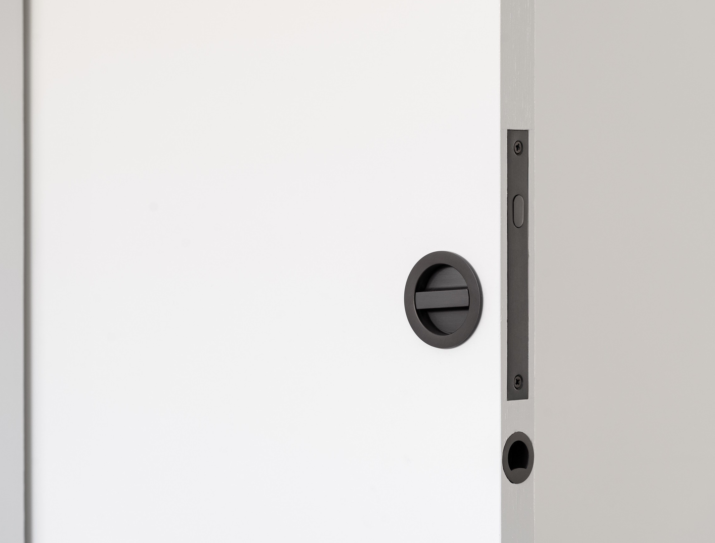 The 8106.GN Gun Metal Grey Sliding Door Privacy Kit installed on a white door.