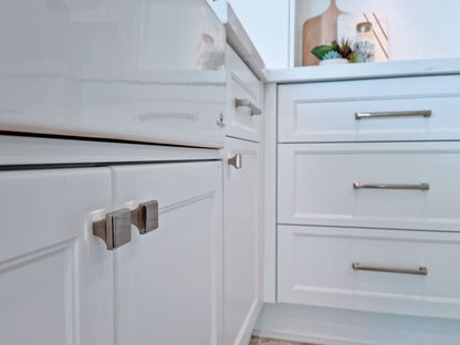 The Manhattan Cabinet knob in brushed nickel on white cabinetry.