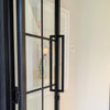 Toorak Matt Black pull handle installed on a glass and wooden door.